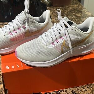 Nike Women's White and Gold Sneakers with Pink Accents